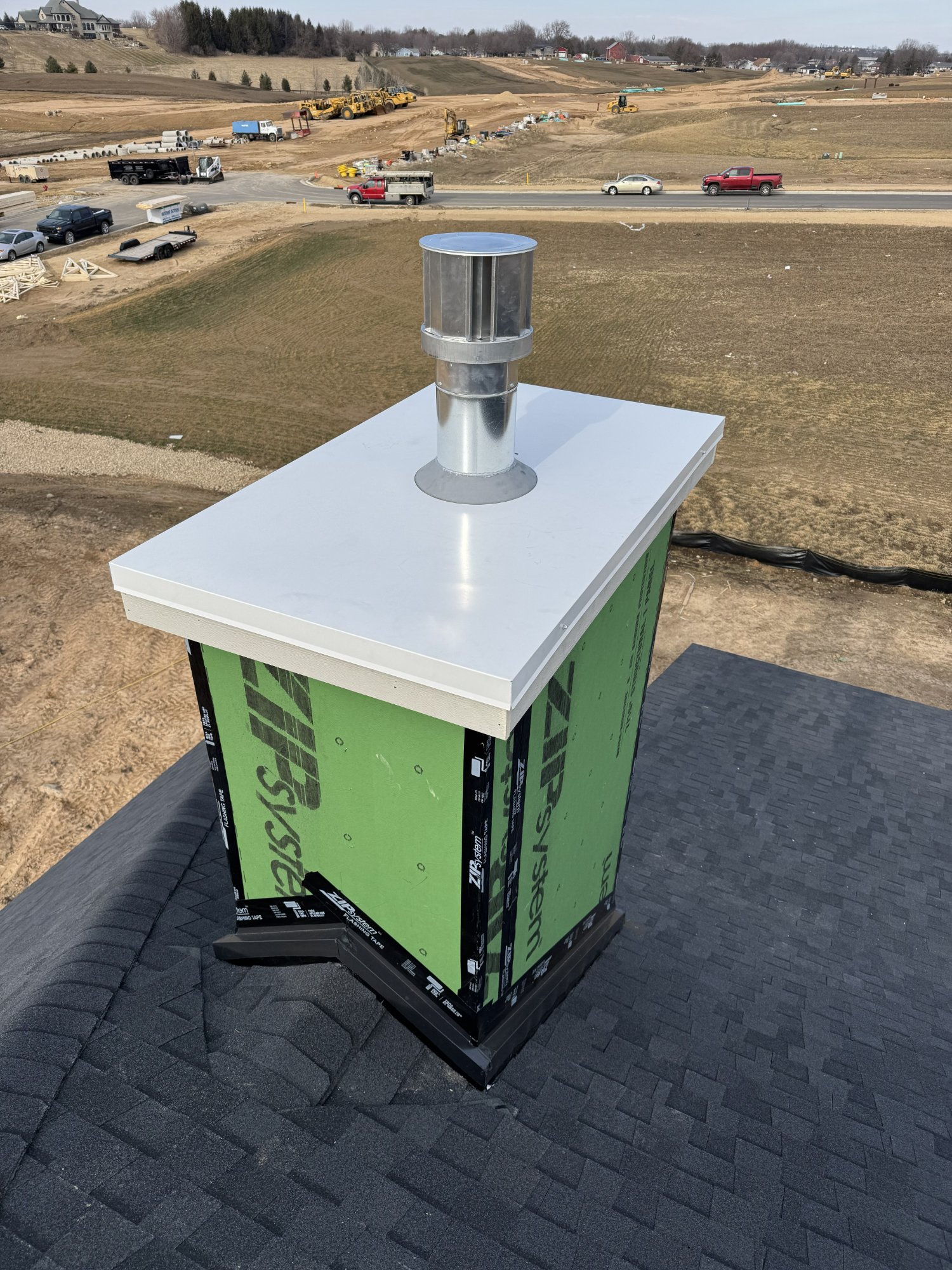 Custom chase pan with chimney cap installed on builder project — Dane County